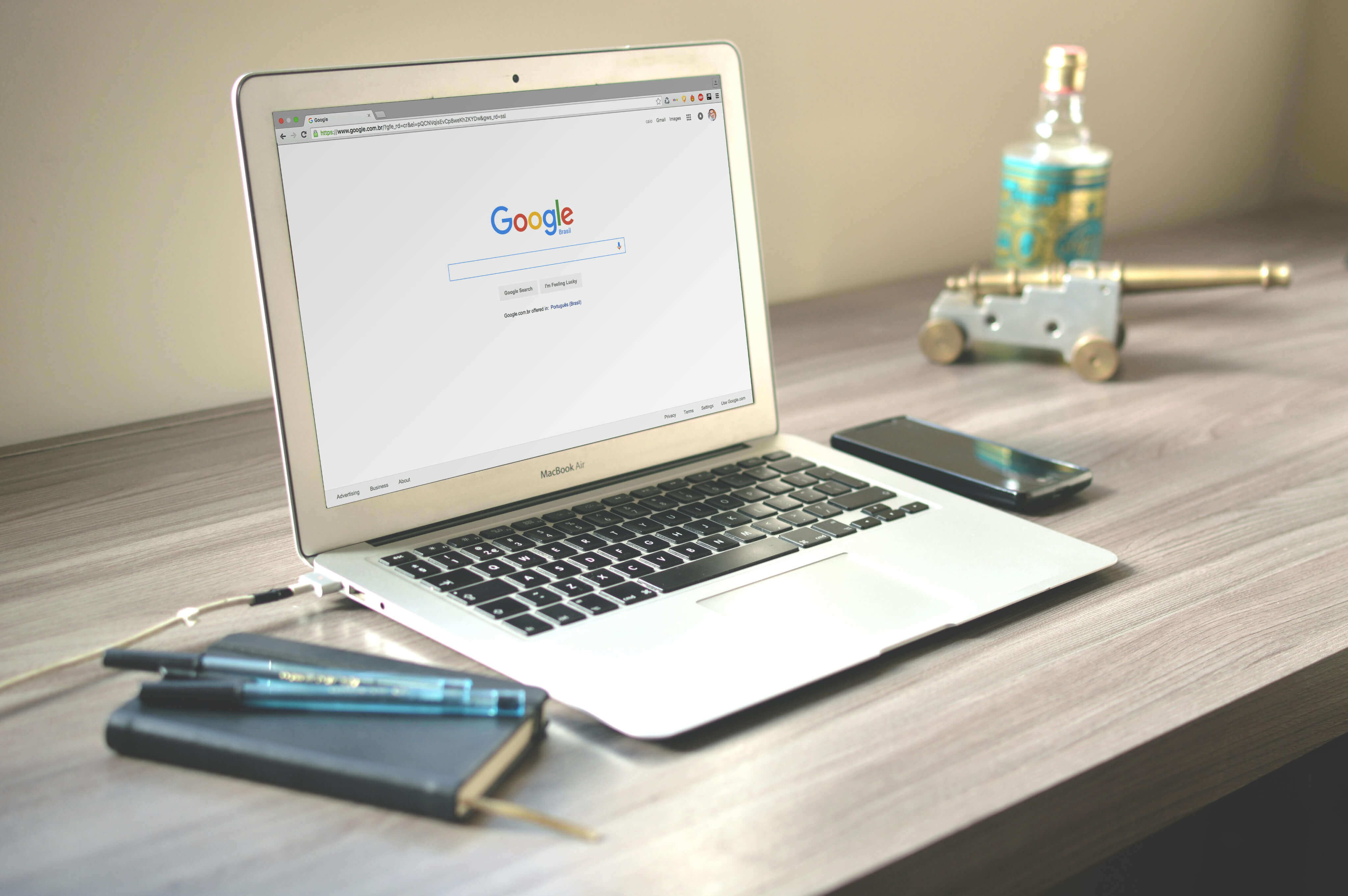 Affordable SEO services for small business shown with a laptop on a desk alongside a notebook, pens, and a mobile phone.